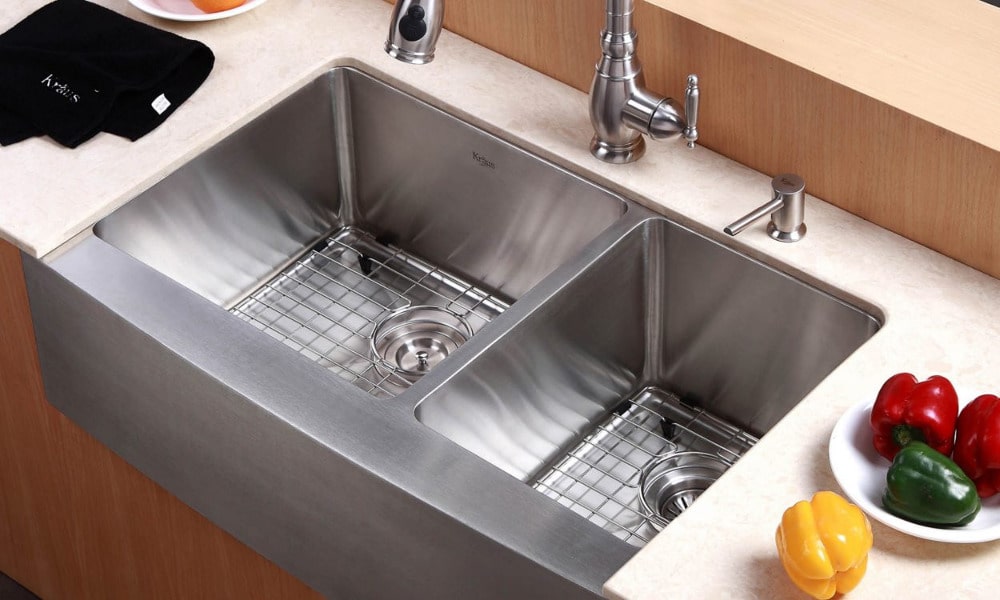 A double kitchen sink with metal strainers in the basins to catch debris.