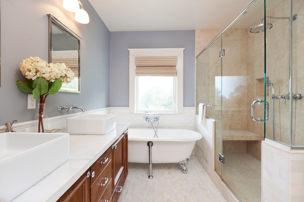 A staged bathroom renovation with claw foot bathtub and large shower enclosure.