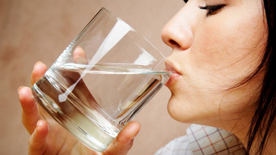 A woman drinking a cup of water